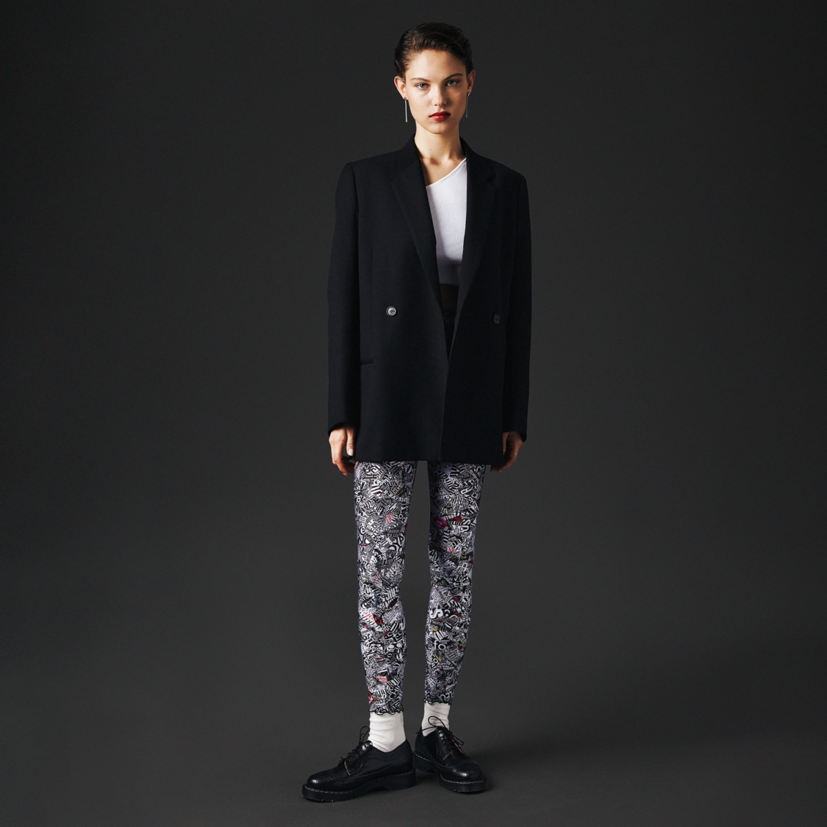 Mannequin en blazer noir et t-shirt blanc portant le legging satiné imprimé Talking Legs femme – vue de face