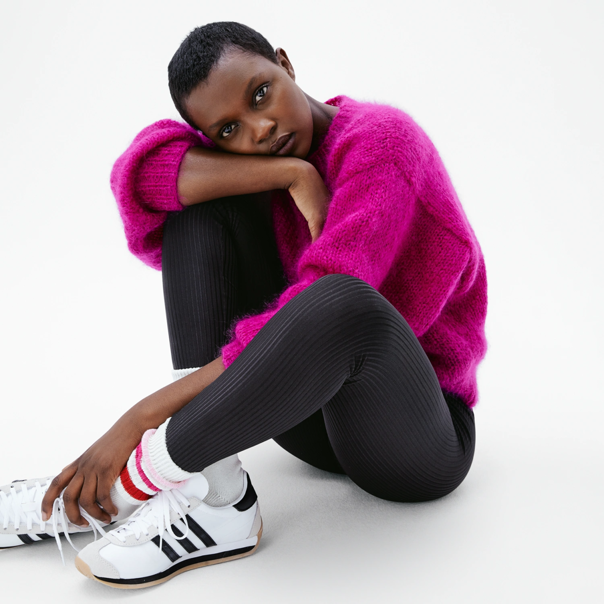 Look casual femme avec legging satiné côtelé Iconic Black et pull oversize, assise