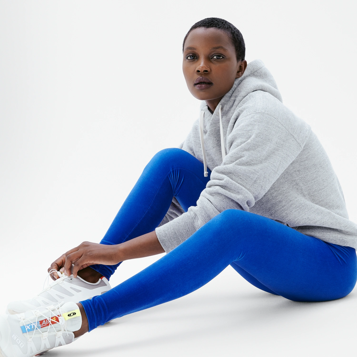 Legging velours bleu électrique coupe classique femme assise casual avec hoodie gris lifestyle