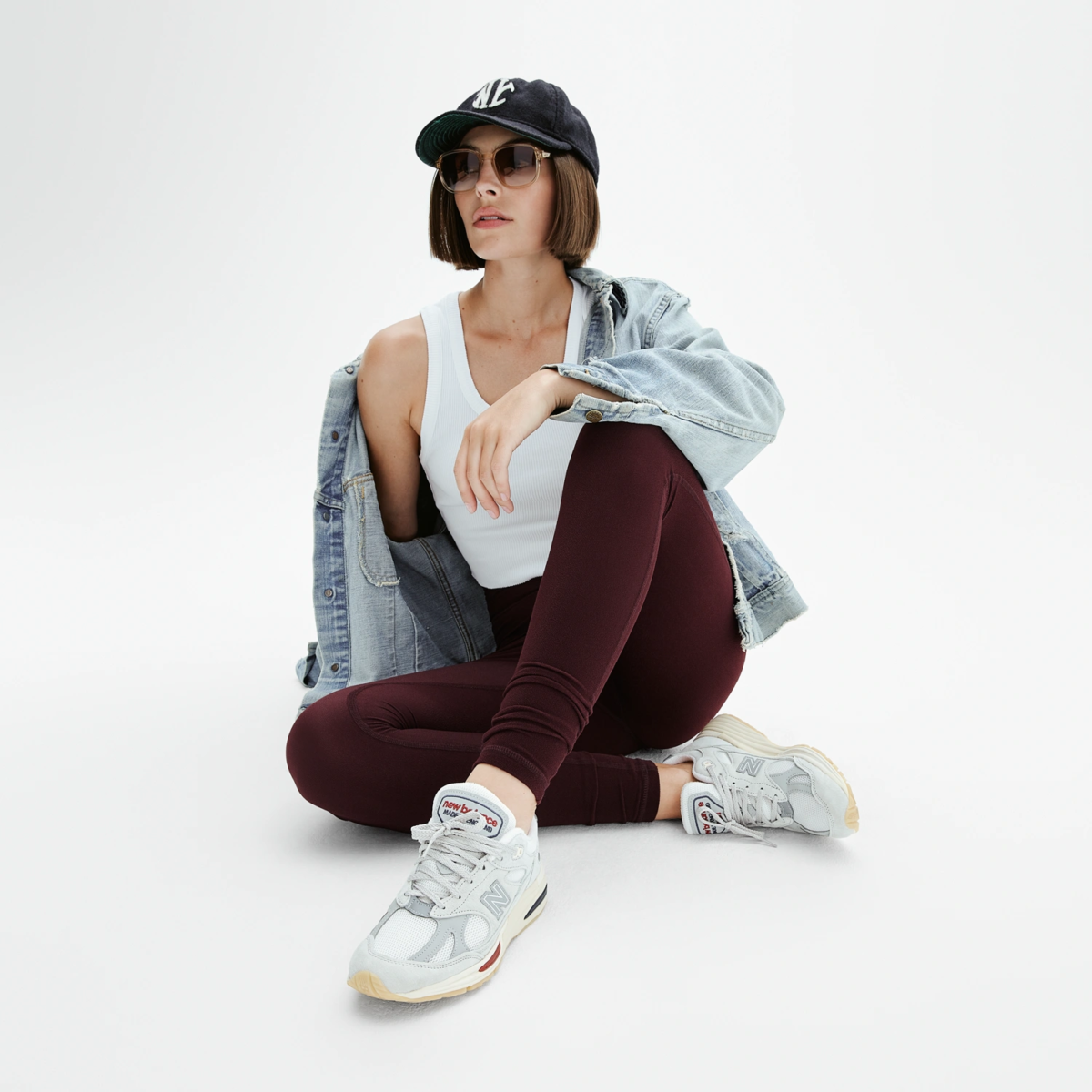 Femme en legging yoga rouge bordeaux coupe sportive, style décontracté avec veste en denim et sneakers