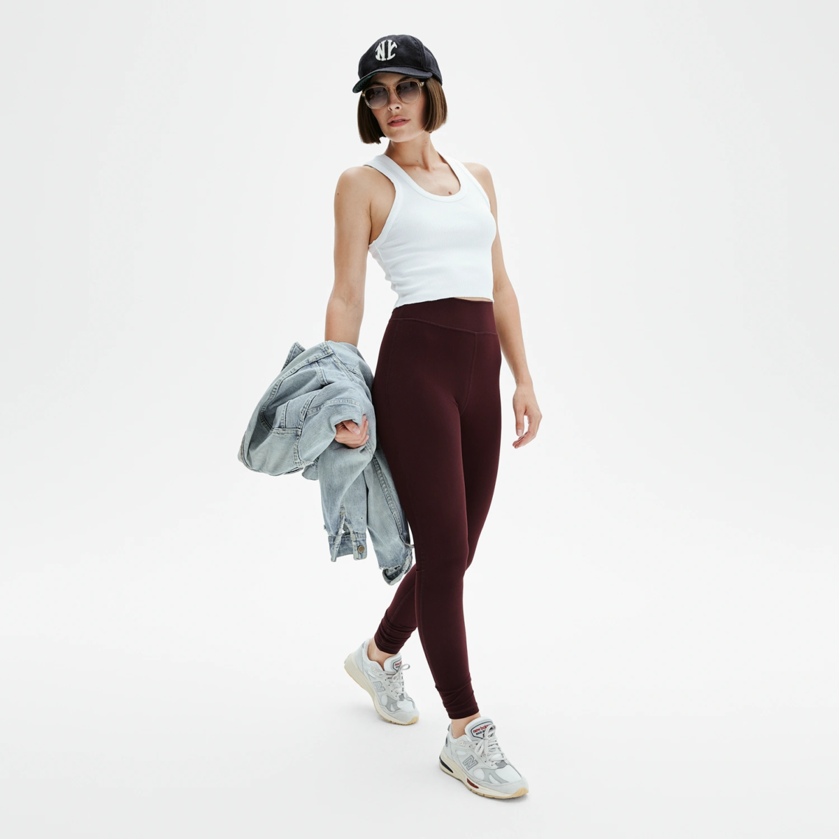 Femme portant legging yoga rouge bordeaux coupe sportive Pattes de Velours Paris, tenue casual avec veste en jean et casquette