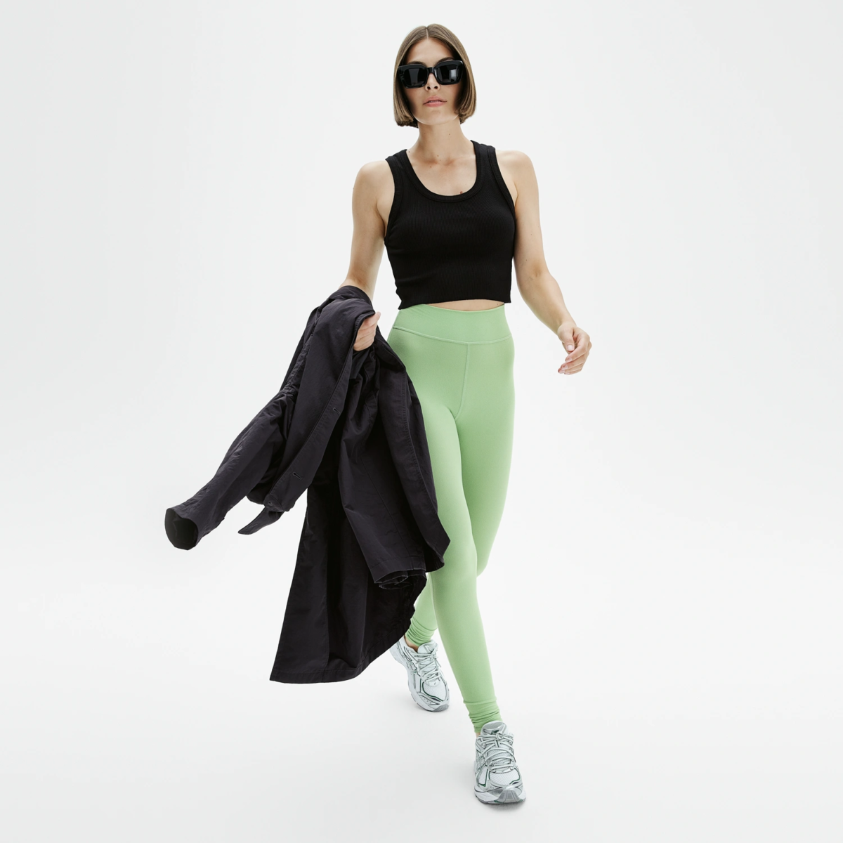 Femme en legging yoga vert evergreen taille haute, style lifestyle sporty chic avec sneakers, Pattes de Velours Paris