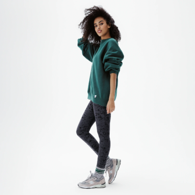 Legging velours texturé noir coupe classique femme porté avec sweat-shirt vert oversize et baskets grises – look lifestyle décontracté