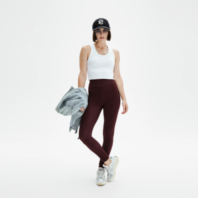 Femme portant legging yoga rouge bordeaux coupe sportive, look casual chic avec sneakers et casquette, Pattes de Velours Paris